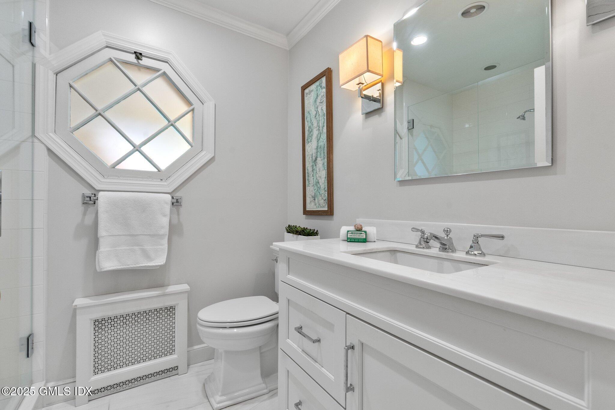 16 Verona Drive Riverside, CT 06878 - Photo 13 of 25 a bathroom with a toilet a sink a vanity a mirror and a window