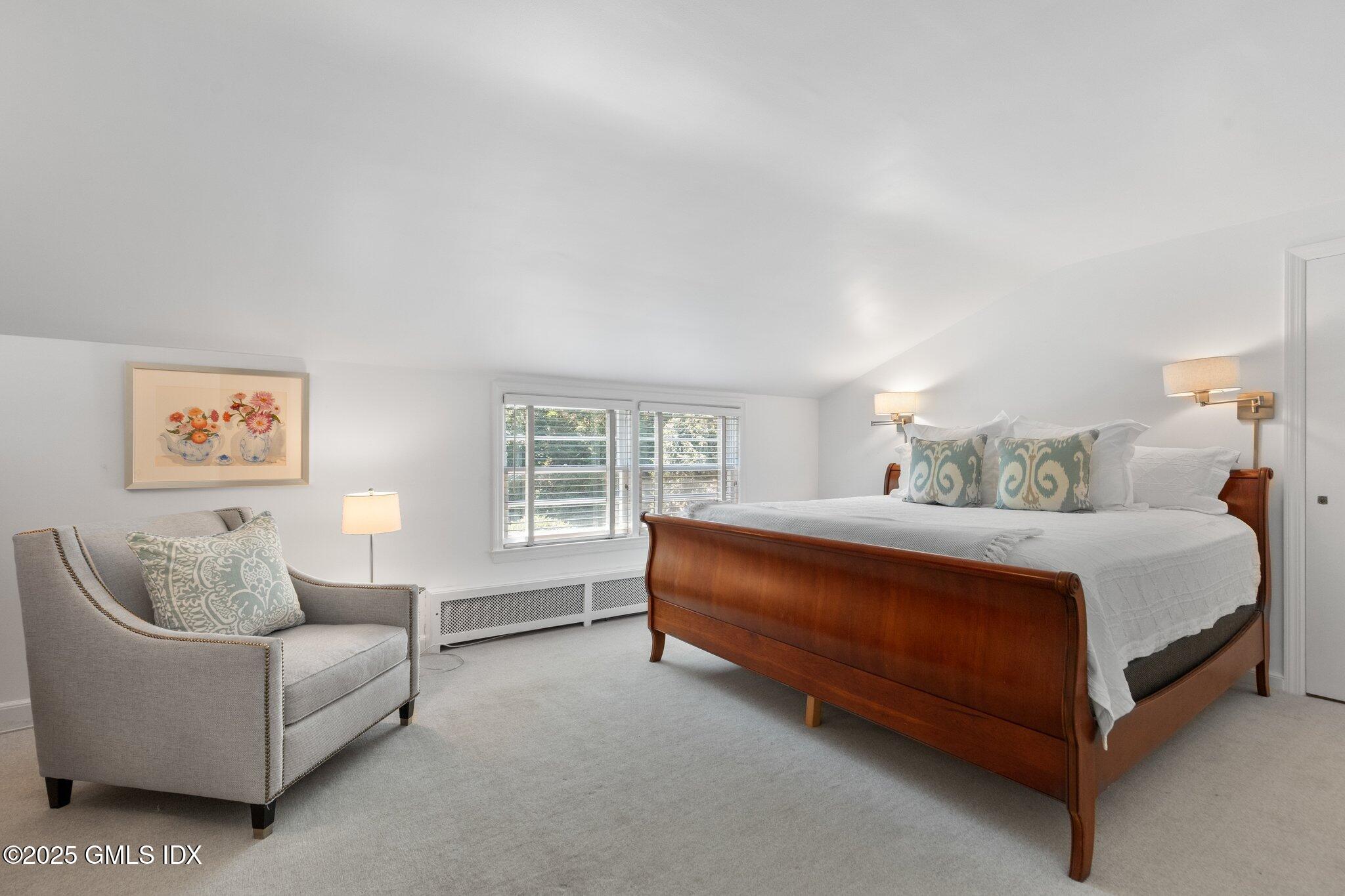 16 Verona Drive Riverside, CT 06878 - Photo 14 of 25 a spacious bedroom with a bed and a couch with window