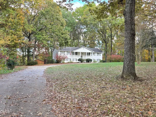 a front view of a house with a yard and trees