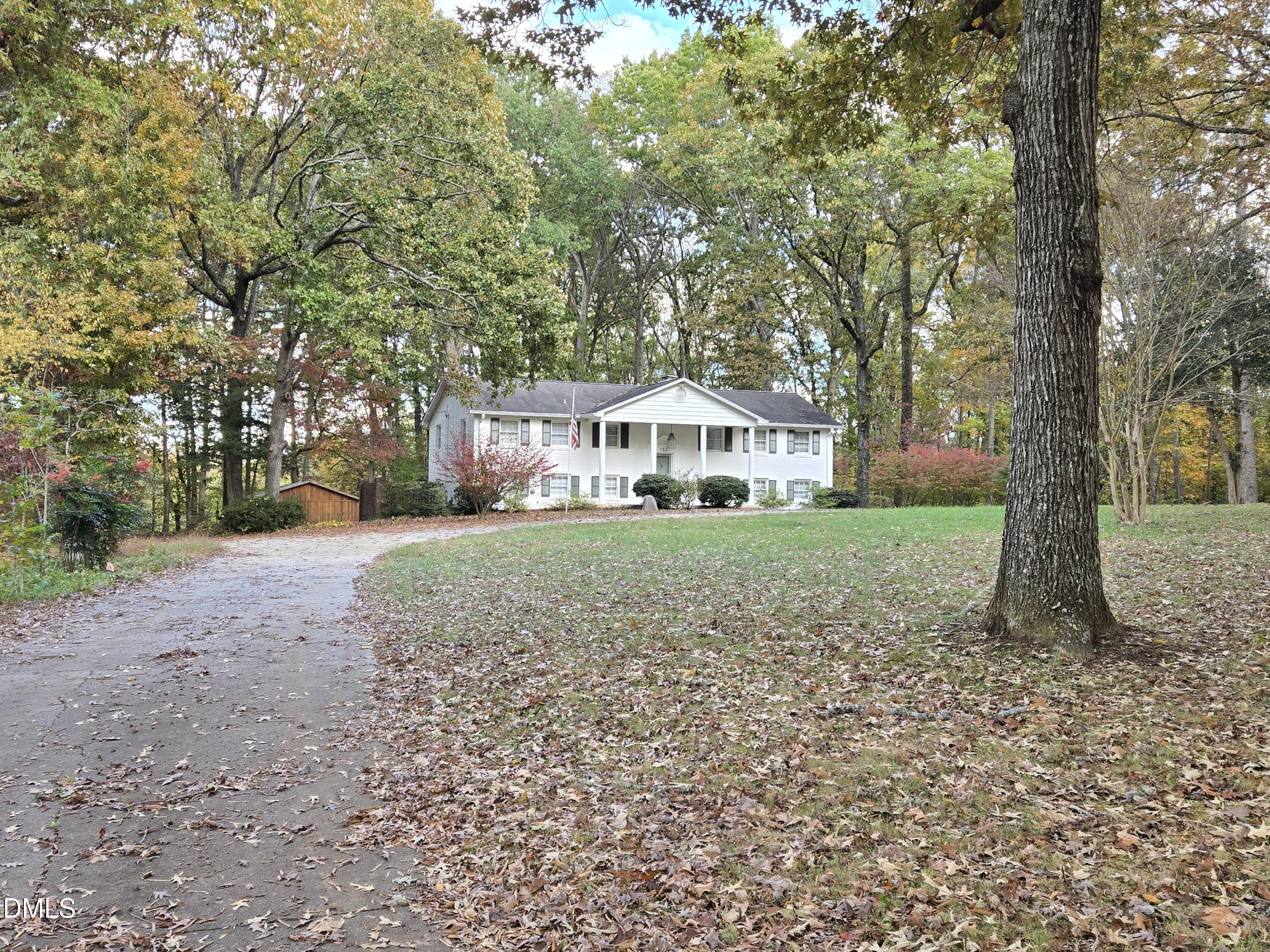 a front view of a house with a yard and trees