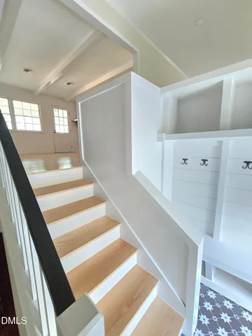 a view of staircase with white walls and a rug