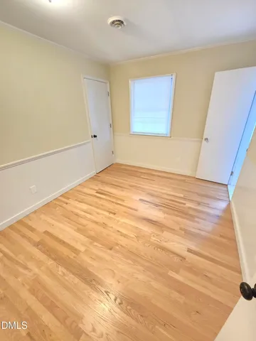 a view of empty room with wooden floor