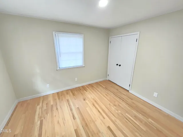 a view of empty room with wooden floor