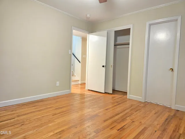 a view of an empty room with wooden floor