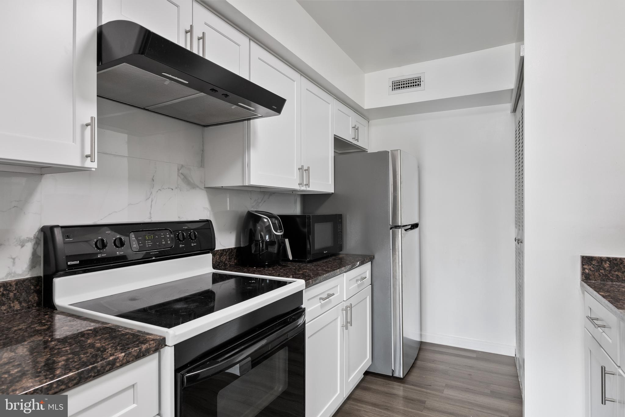 117 Sandra Road Voorhees, NJ 08043 - Photo 13 of 25 a kitchen with stainless steel appliances granite countertop a stove a refrigerator and a sink with wooden floor