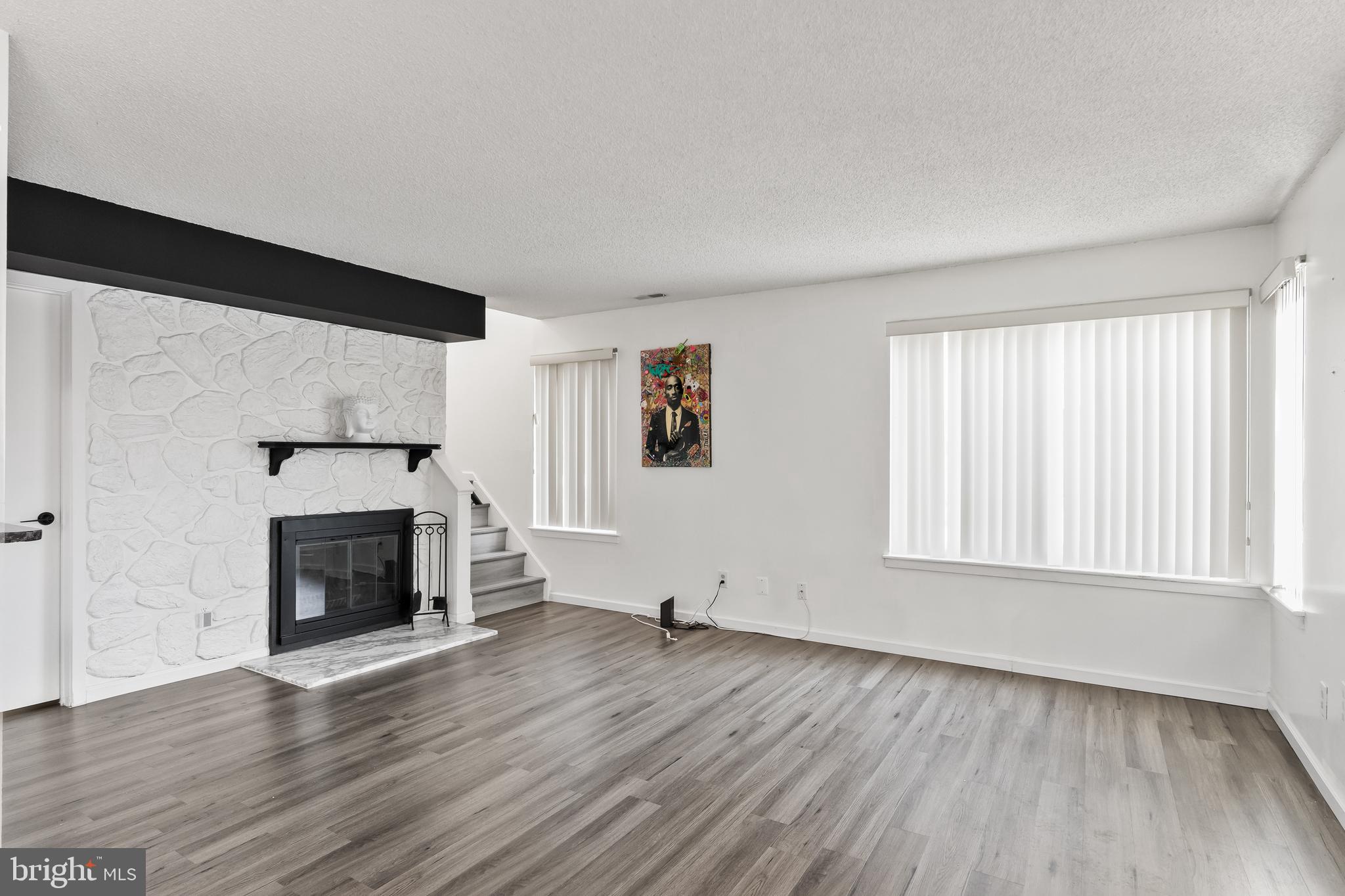 117 Sandra Road Voorhees, NJ 08043 - Photo 6 of 25 an empty room with wooden floor fireplace and windows