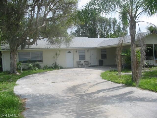 7449 Pebble Beach Road Fort Myers, FL 33967 - Photo 1 of 21 a front view of a house with a yard and potted plants