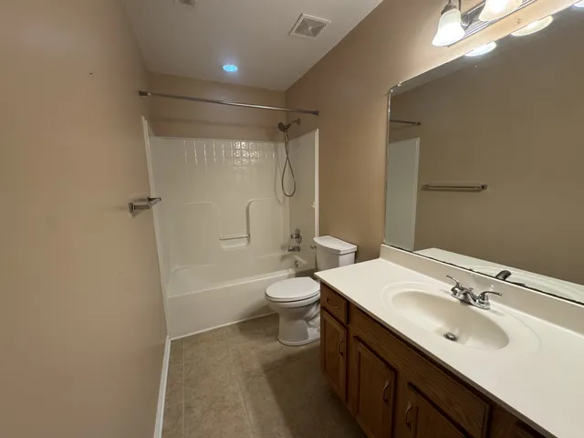 a bathroom with a double vanity sink toilet mirror and shower