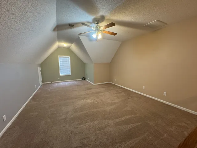 an empty room with closet and a ceiling fan