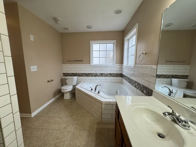 a bathroom with a granite countertop tub sink and mirror