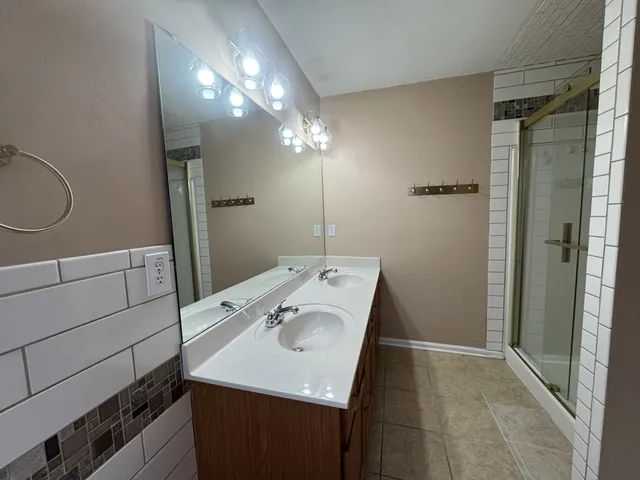 a bathroom with a sink vanity and shower