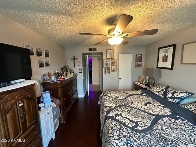 a bedroom with a bed and a flat tv screen on the dresser