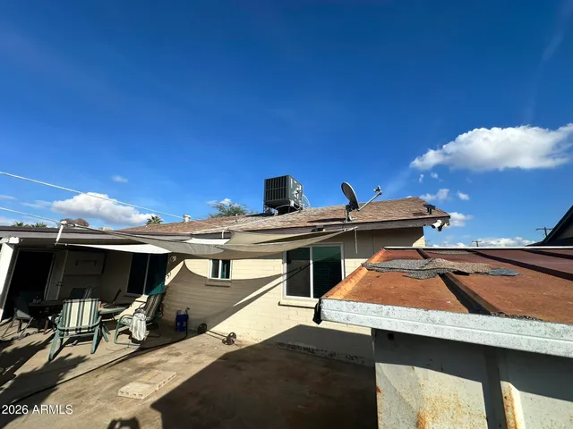 a view of a patio with table and chairs under an umbrella with wooden fence