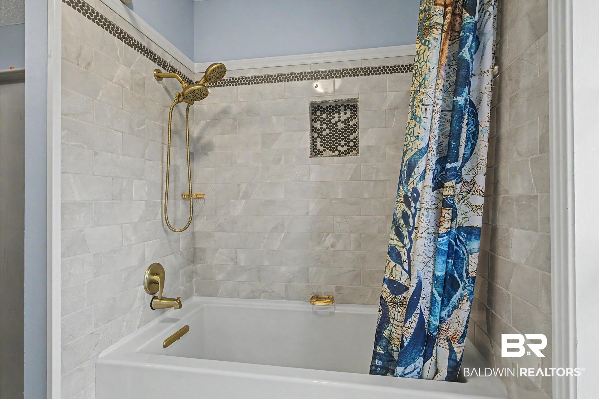 3791 Robinsonville Road Atmore, AL 36502 - Photo 40 of 47 Tiled tub-shower combination featuring a recessed niche with mosaic tile, a dual-function shower head, and brass-finish fixtures