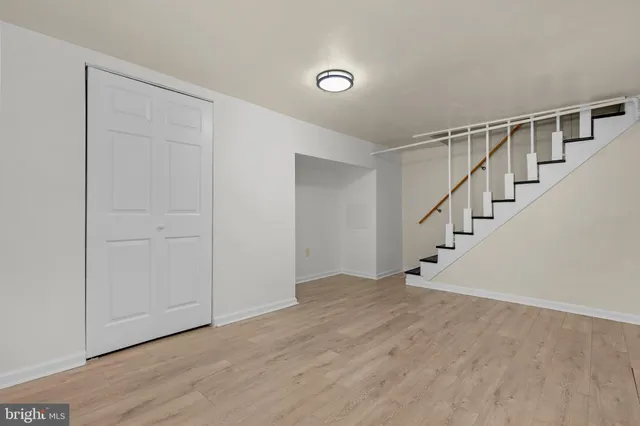 a view of an empty room with wooden floor and entryway