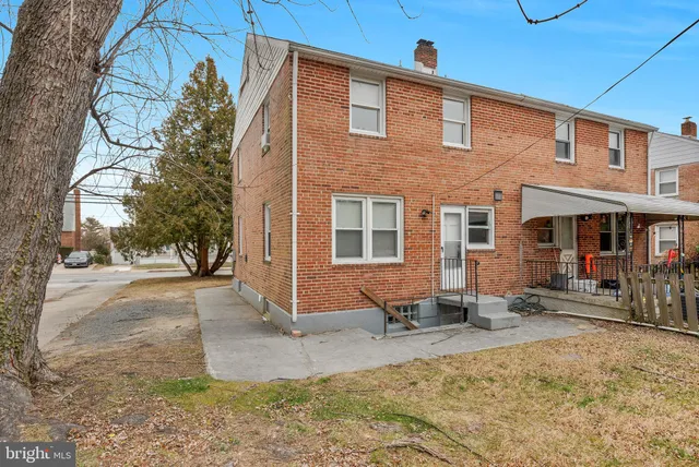 a front view of a house with a yard outdoor seating and covered with snow