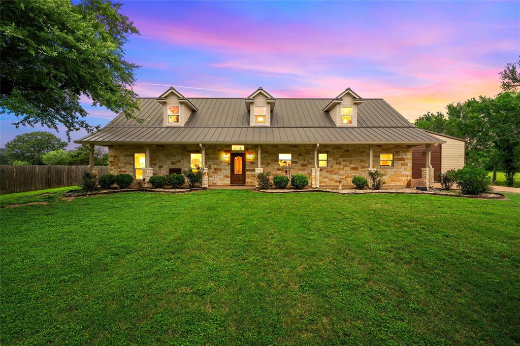 1117 Downsville Road Robinson, TX 76706 - Photo 1 of 40 Stone-clad residence featuring a metal roof, dormer windows, and an expansive front lawn with mature trees