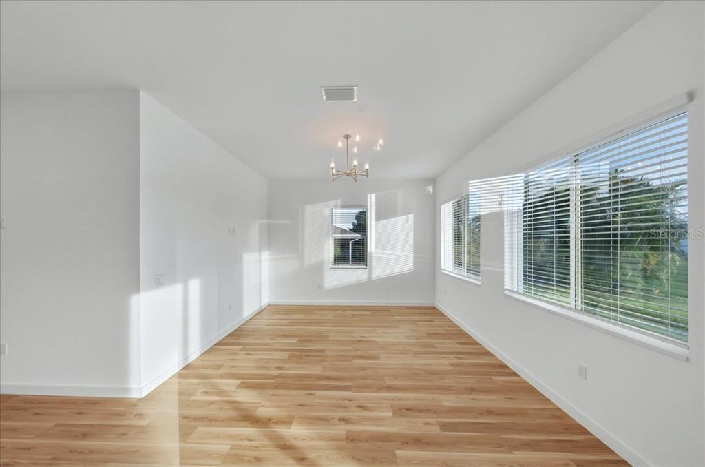 1215 Rio De Janeiro Avenue Punta Gorda, FL 33983 - Photo 20 of 65 a view of an empty room with a window and wooden floor
