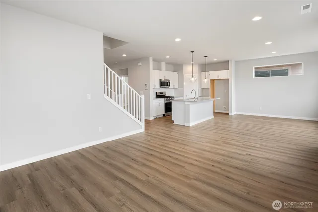a view of a kitchen with wooden floor and windows
