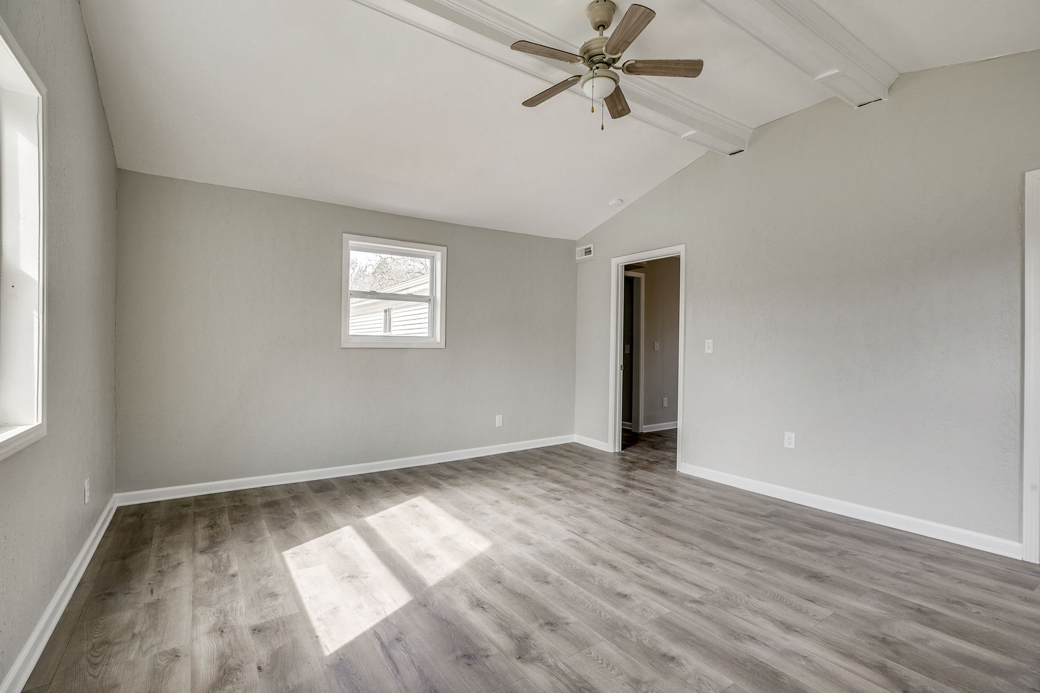 335 Eva Harbor Road Eva, TN 38333 - Photo 21 of 32 an empty room with wooden floor chandelier fan and windows