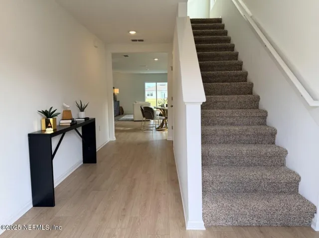a view of a hallway with wooden floor and furniture