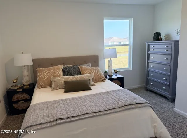 a bedroom with a bed a dresser and a window