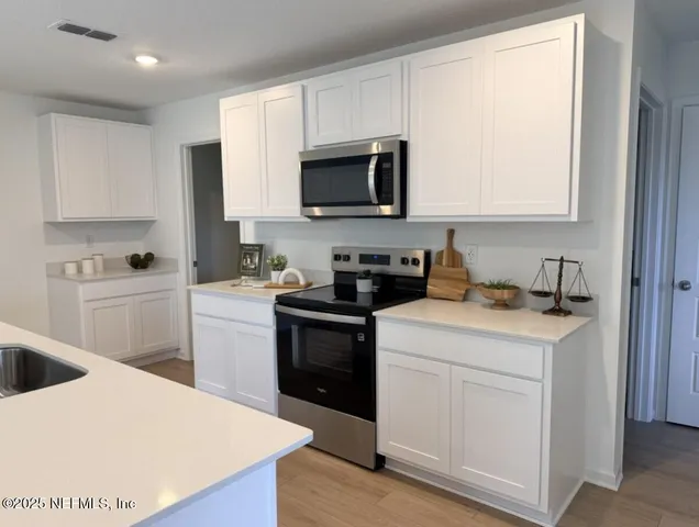 a kitchen with a sink a stove and cabinets