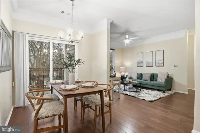 a dining room with furniture a chandelier and wooden floor