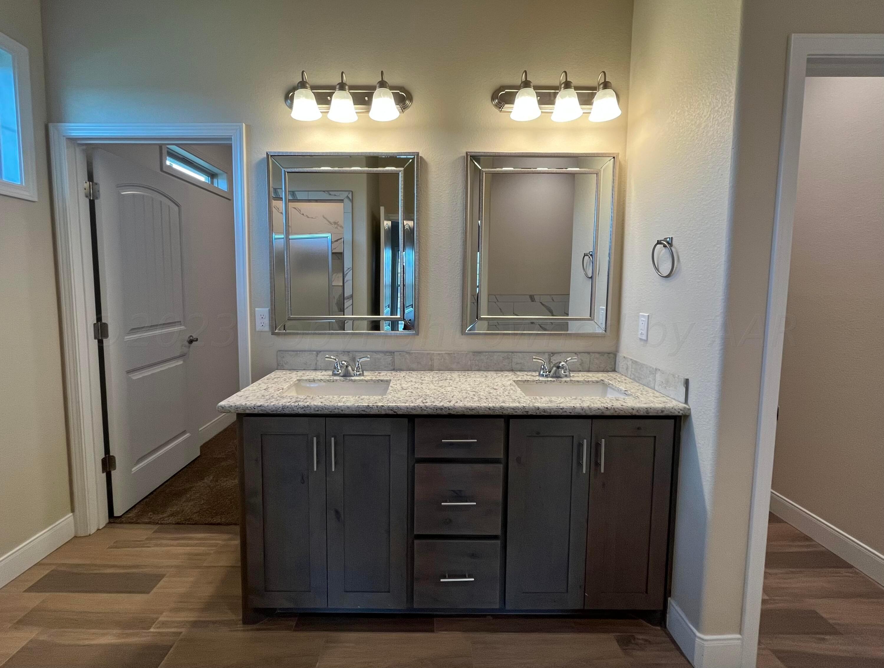 7610 Crestline Drive Amarillo, TX 79119 - Photo 5 of 9 a bathroom with a double vanity sink and a mirror