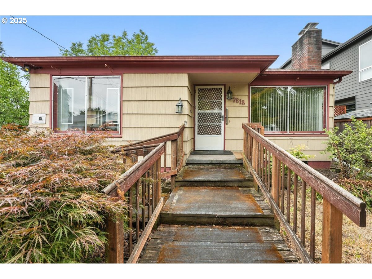 a view of a house with wooden floor next to a yard
