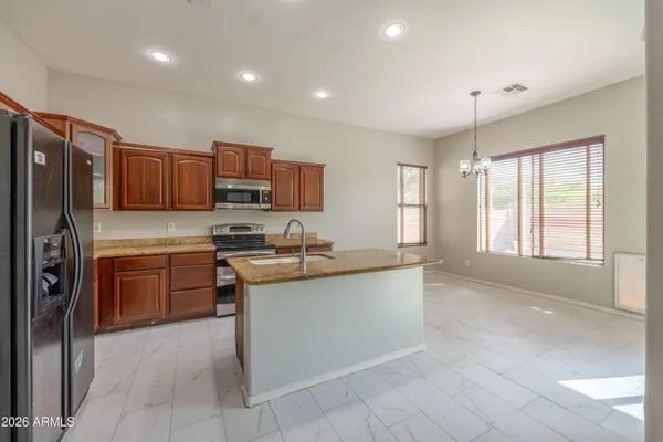 a kitchen with stainless steel appliances granite countertop a refrigerator stove and sink