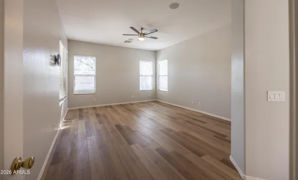 an empty room with wooden floor and windows