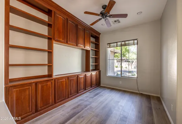 a view of an empty room with a window and wooden floor