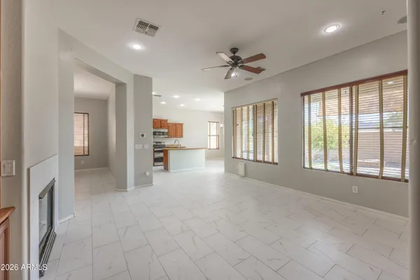 a view of an empty room with a window and a kitchen