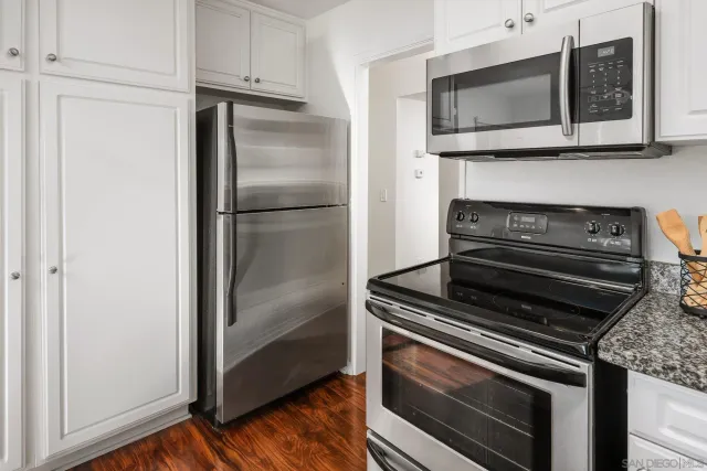 a bedroom with a bed and a refrigerator