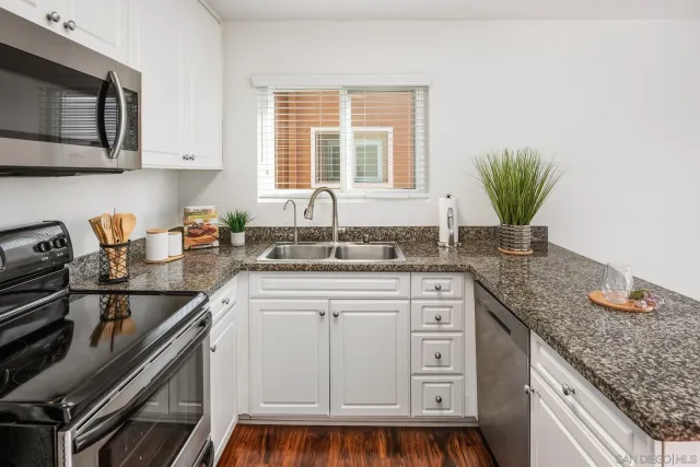 a bathroom with a granite countertop sink a toilet and a mirror