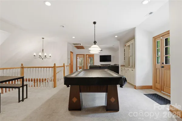 a spacious bedroom with a bed a couch and a chandelier