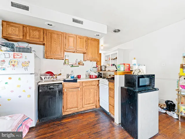 a open kitchen with stainless steel appliances granite countertop a refrigerator and a stove top oven