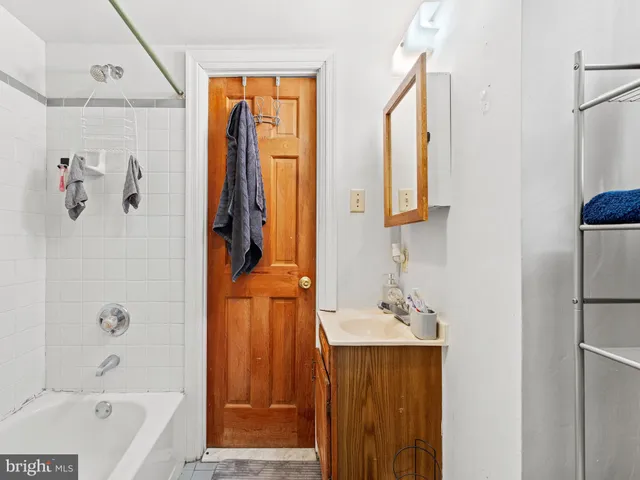 a bathroom with a tub sink and mirror