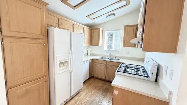 a kitchen with stainless steel appliances a refrigerator sink and white cabinets