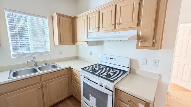 a kitchen with white cabinets and a stove top oven