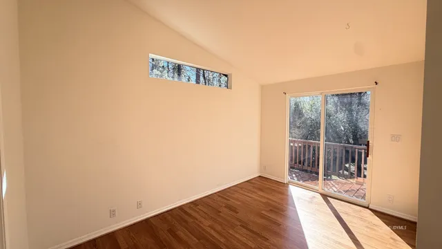 a view of a room with wooden floor and windows