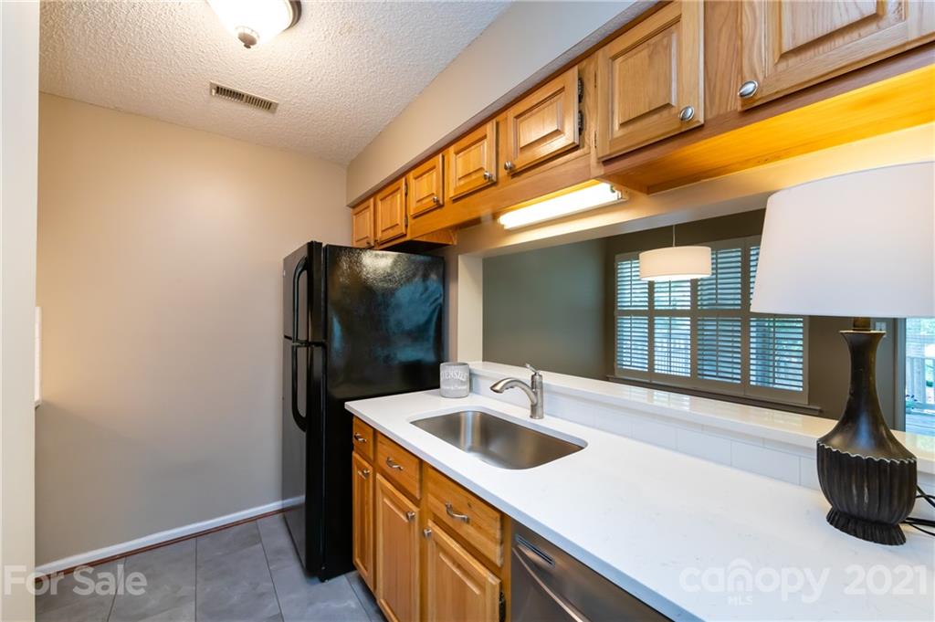 5003 Sharon Road, Unit G Charlotte, NC 28210 - Photo 16 of 42 a kitchen with a sink and cabinets