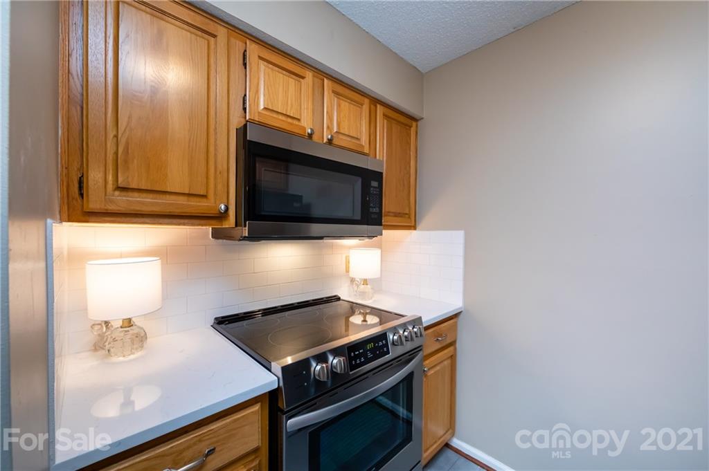 5003 Sharon Road, Unit G Charlotte, NC 28210 - Photo 17 of 42 a kitchen with a stove and a microwave