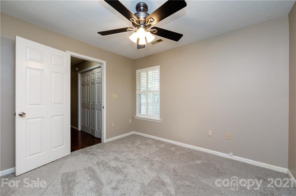 5003 Sharon Road, Unit G Charlotte, NC 28210 - Photo 22 of 42 an empty room with closet and a ceiling fan
