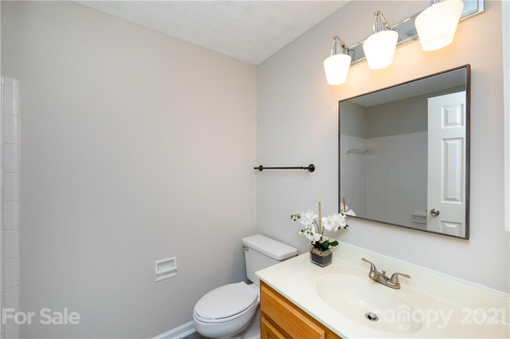 5003 Sharon Road, Unit G Charlotte, NC 28210 - Photo 24 of 42 a bathroom with a sink vanity mirror and toilet