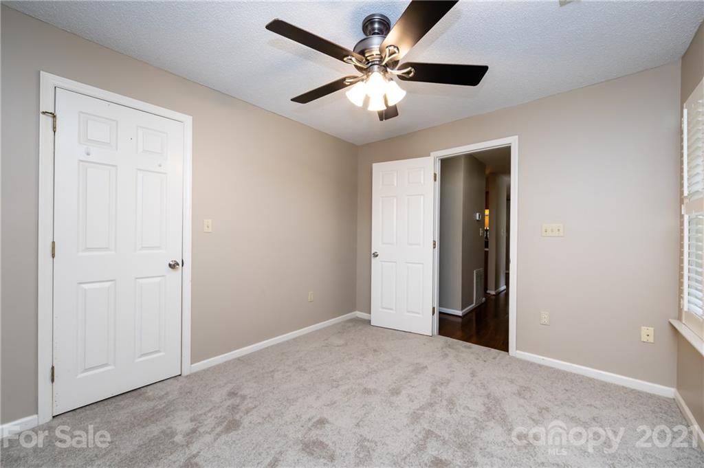 5003 Sharon Road, Unit G Charlotte, NC 28210 - Photo 26 of 42 an empty room with closet and a chandelier fan