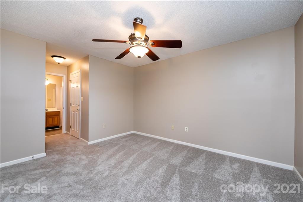 5003 Sharon Road, Unit G Charlotte, NC 28210 - Photo 27 of 42 an empty room with closet and a chandelier fan
