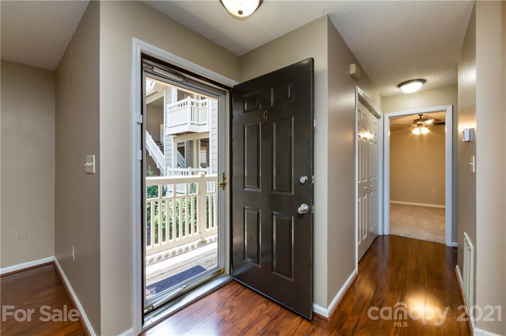 5003 Sharon Road, Unit G Charlotte, NC 28210 - Photo 6 of 42 a view of a hallway with wooden floor and a livingroom