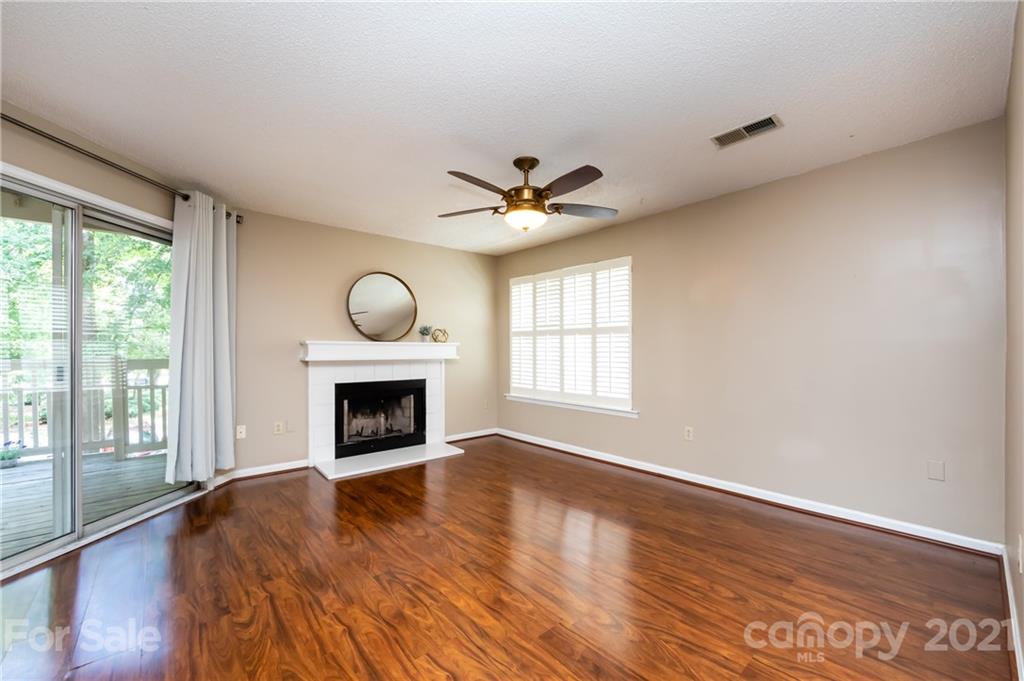5003 Sharon Road, Unit G Charlotte, NC 28210 - Photo 7 of 42 an empty room with fireplace fan and windows